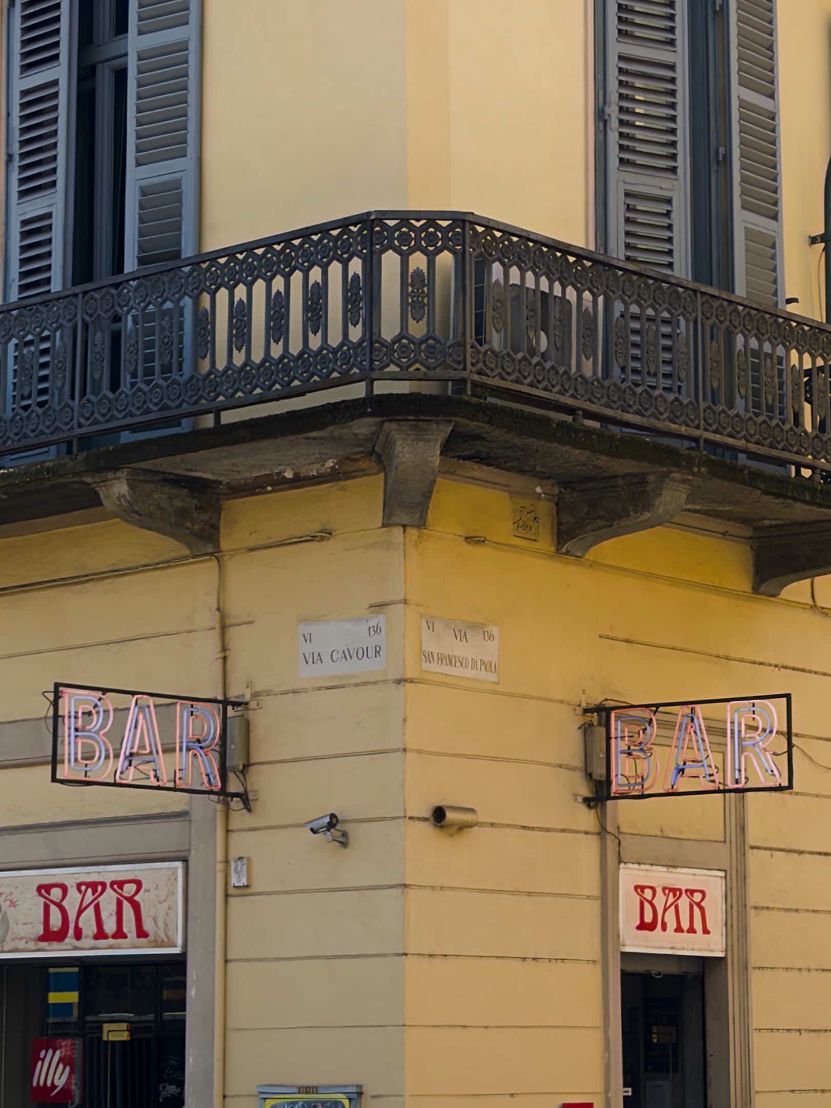 Un angolo di un edificio con l insegna rossa con la scritta bar